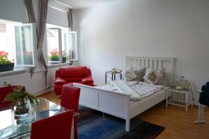 sala de estar con cama y silla roja en Cafe Alice & Pension GmbH, en Potsdam