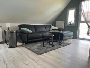 a living room with a couch and a table at Moderne Ferienwohnung in Spaden / Wasserski / Badesee in Schiffdorf