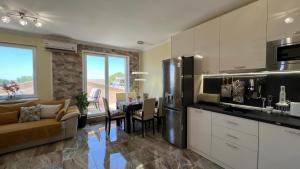 eine Küche und ein Wohnzimmer mit einem Tisch und einem Kühlschrank in der Unterkunft Bratanov Vip Zone maisonettes 606 & 609 in Sonnenstrand