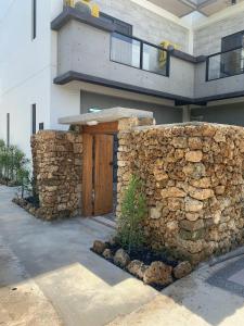 uma casa com uma parede de pedra e uma porta de madeira em 砝泥民宿 12位包棟6間雙人房訂房前加line 有優惠 em Magong