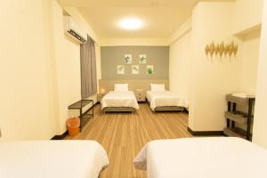 um quarto de hospital com três camas em 喜苑民宿 em Jinhu