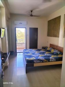 a bedroom with a bed with a blue comforter at HOTEL ROYAL PARADISE in Coimbatore