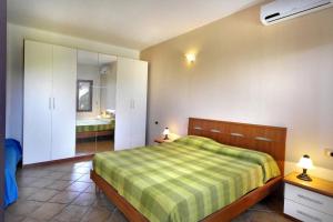 a bedroom with a bed and a bathroom with a sink at Le Villette di Capo Testa in Santa Teresa Gallura