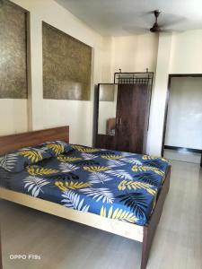 een slaapkamer met een bed met een blauwe en gele deken bij HOTEL ROYAL PARADISE in Coimbatore