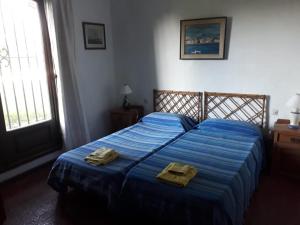 a bedroom with a blue bed with two towels on it at Haras L'Etalon in Pergamino