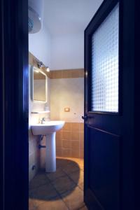 a bathroom with a sink and a mirror and a door at Le Villette di Capo Testa in Santa Teresa Gallura