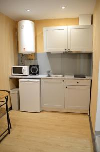 a small kitchen with white cabinets and a microwave at SÃO VICTOR Studios HISTORIC CENTER in Braga