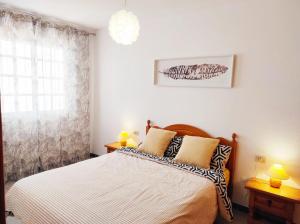 una camera da letto con un letto con due lampade e una finestra di Almichara a El Médano Altre 2 foto
