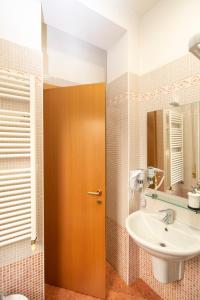 a bathroom with a sink and a wooden door at Vitti's Home Verona 3 in Verona