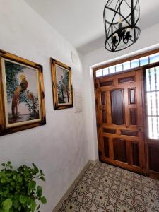 een hal met een deur en schilderijen aan de muur bij Casa rural La Golondrina in Villarta de San Juan