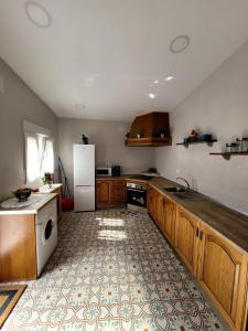 - une cuisine avec des placards en bois et un réfrigérateur blanc dans l'établissement Casa rural La Golondrina, à Villarta de San Juan