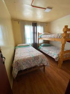 a bedroom with two bunk beds and a window at Hostel 53 Sur in Puerto Natales