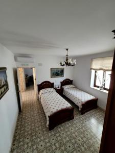 een slaapkamer met 2 bedden en een kroonluchter bij Casa rural La Golondrina in Villarta de San Juan