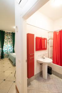 ein Bad mit einem Waschbecken und einer roten Tür in der Unterkunft Vitti's Home Verona 3 in Verona