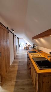 a kitchen with wooden counters and a long hallway at Naturhof Buschwiesen - Wohnung Lama in Wilsum