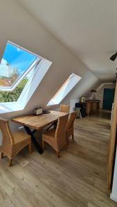 uma sala de jantar com uma mesa e duas janelas em Naturhof Buschwiesen - Wohnung Lama em Wilsum