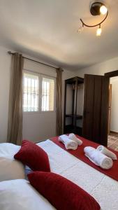 een slaapkamer met 2 bedden en rode en witte handdoeken bij Casa en El Patras, Almonaster la Real in Patrás