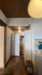 een keuken met een witte koelkast en een tegelvloer bij Casa en El Patras, Almonaster la Real in Patrás