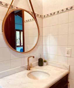 W łazience znajduje się umywalka i lustro. w obiekcie Maui Suítes e Chalés w mieście Arraial d'Ajuda