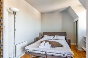 1 dormitorio con 1 cama con 2 toallas en Apartment with a balcony and a pool - Welkeys, en Deauville