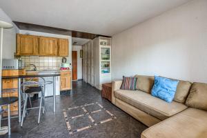 a living room with a couch and a kitchen at Appartement Bréguières - Welkeys in Antibes