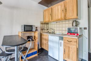 a small kitchen with a table and a microwave at Appartement Bréguières - Welkeys in Antibes