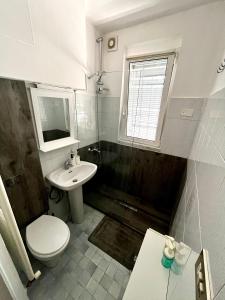 a bathroom with a toilet and a sink and a window at Gionas - Casa indipendente in zona strategica in Milan