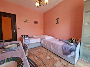 a bedroom with two beds and a table at [P.ZZA MARCONI] Bilocale per la vacanza al mare in Pietra Ligure