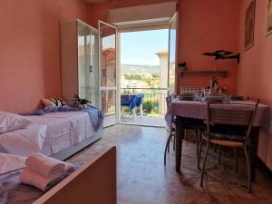 a bedroom with a bed and a table and a balcony at [P.ZZA MARCONI] Bilocale per la vacanza al mare in Pietra Ligure