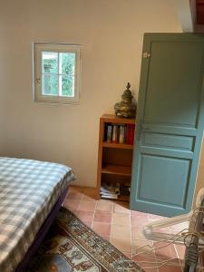 sypialnia z łóżkiem i zielonymi drzwiami w obiekcie Maisonnette proche de la mer, calme avec parking w mieście Angoulins