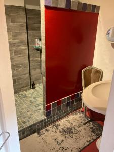 łazienka z prysznicem i czerwoną ścianą w obiekcie Maisonnette proche de la mer, calme avec parking w mieście Angoulins