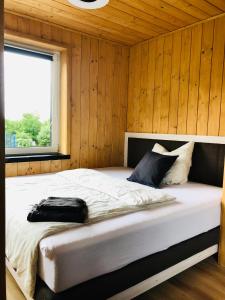 1 dormitorio con 1 cama en una pared de madera en Ruhige Ferienwohnung direkt am Rennsteig, en Igelshieb