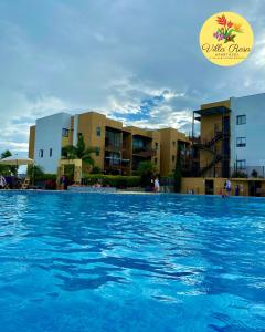 - une piscine d'eau bleue en face des bâtiments dans l'établissement Apartasol Villa Rosa, Reserva de la Colina, La Tebaida, Quindio, à La Tebaida