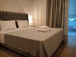 een slaapkamer met een bed met twee handdoeken erop bij CA Comfort Living in Kalamata