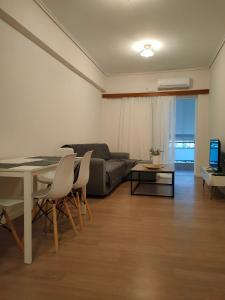 a living room with a table and a couch at CA Comfort Living in Kalamata