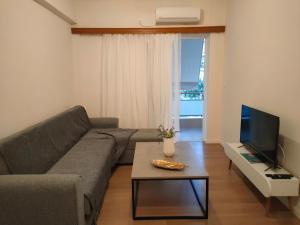 a living room with a couch and a tv at CA Comfort Living in Kalamata