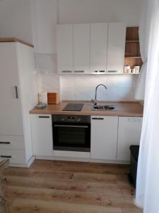 a kitchen with white cabinets and a sink at Galeb in Rijeka