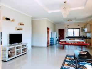 a living room with a television and a table at Sweet Retreat in Lusaka
