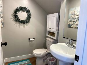 a bathroom with a toilet and a sink and a mirror at Lovely Condo! W/ free recreational vehicle parking in Garden City