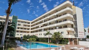 un hotel con piscina frente a un edificio en Playa del Ingles D&M near Yumbo en San Bartolomé