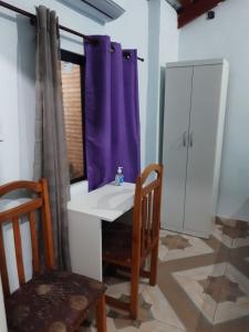 baño con lavabo y cortina de ducha púrpura en Monoambiente semi independiente en Asu-Py, en Asunción