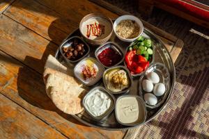 un plato de comida con salsas y otros alimentos en una mesa en Desert Shade camp חוות צל מדבר, en Mitzpe Ramon