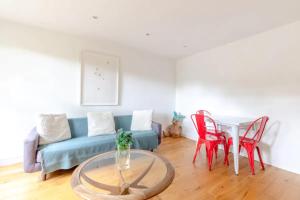 a living room with a blue couch and red chairs at Spacious 1 Bedroom Apartment in Vibrant Angel in London