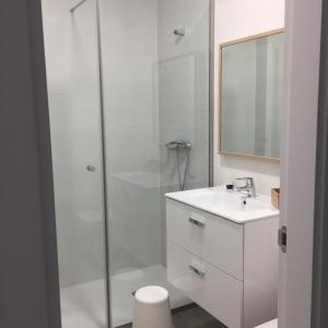 a white bathroom with a shower and a sink at Casa Valsain in La Granja de San Ildefonso