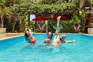 three people playing with frisbees in a swimming pool at Hotel Villas Colibrí Suites & Bungalows in Cozumel