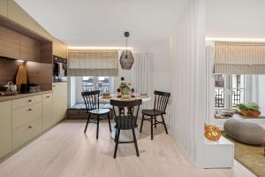a kitchen and dining room with a table and chairs at West Side Piotrkowska Apartment in Łódź