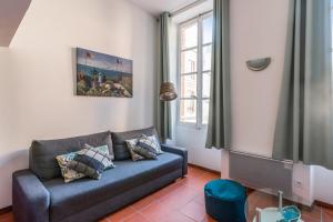 Superb apartment located on the main square - Toulouse - Welkeys في تولوز: غرفة معيشة مع أريكة ونافذة