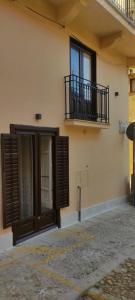 ein Gebäude mit einem Balkon, einer Tür und einem Fenster in der Unterkunft Casa Vacanze Margherita in Castellammare del Golfo