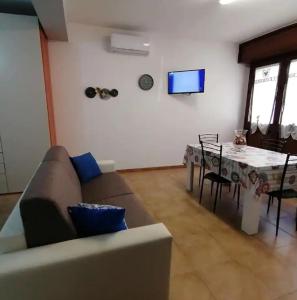 uma sala de estar com um sofá e uma mesa de jantar em La casa di Anita nel cuore di Segesta em Calatafimi