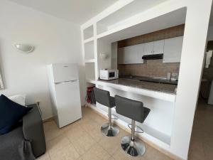 cocina con encimera y nevera blanca en Oasis Blue - beautiful 1 bedroom apartment on private complex with pool en Tías